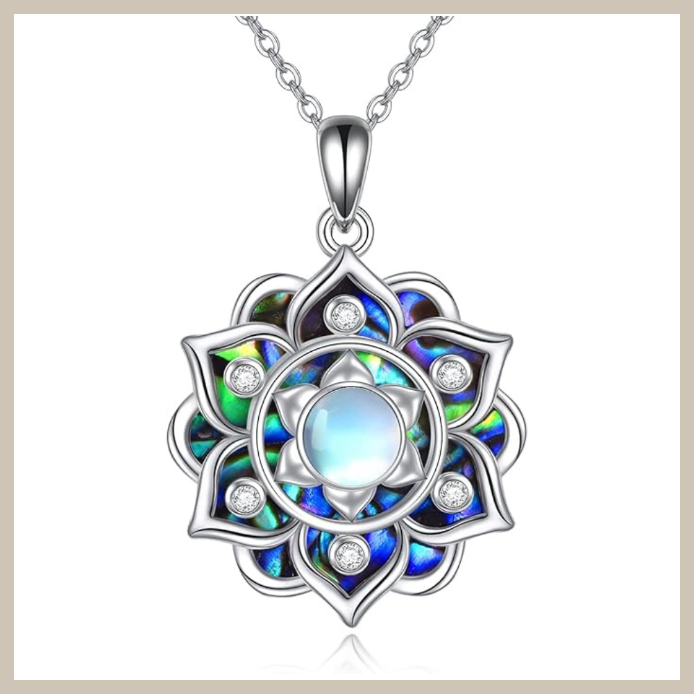 Sterling silver lotus flower pendant with layered petal design and iridescent blue abalone-style inlay surrounding a central round moonstone, on a silver cable chain.