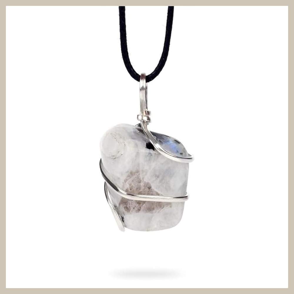 Raw moonstone crystal wrapped in silver wire, suspended from a black cord necklace in a natural, organic pendant style.